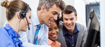 Manager with call center team using tablet PC in office